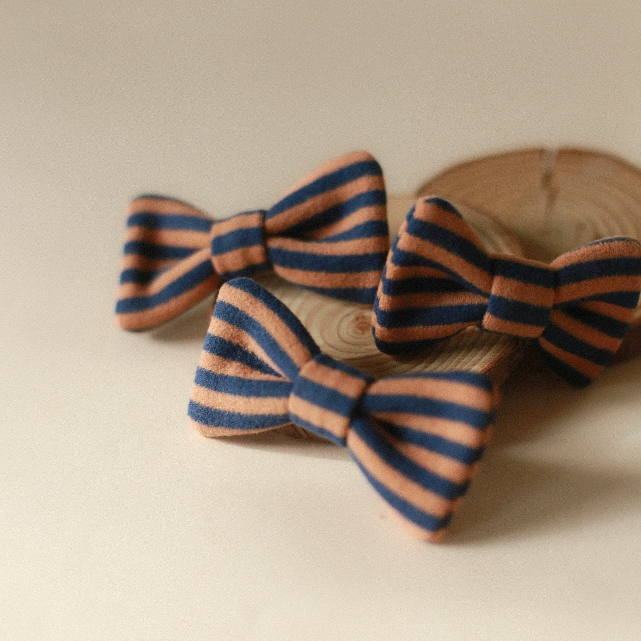 Two striped hair bows from Lilco's Essentials Collection, featuring a stylish design in a neutral color palette. Perfect for adding a touch of charm to any outfit.